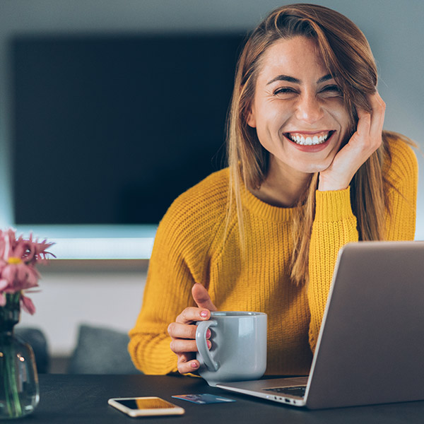 woman laughing at her laptop