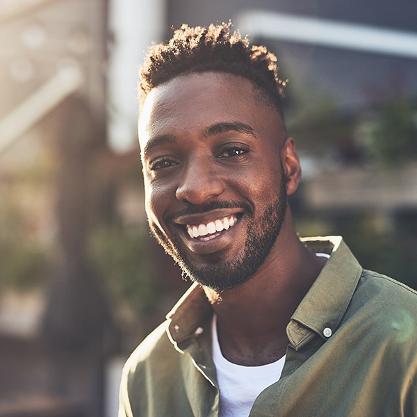 young man smiling outside