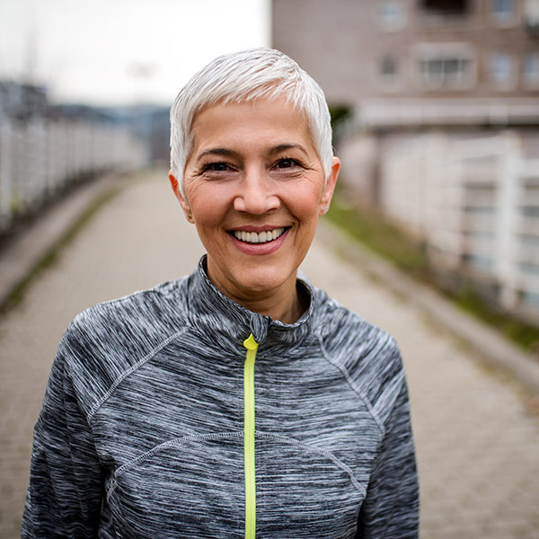 mature woman out for a jog smiling
